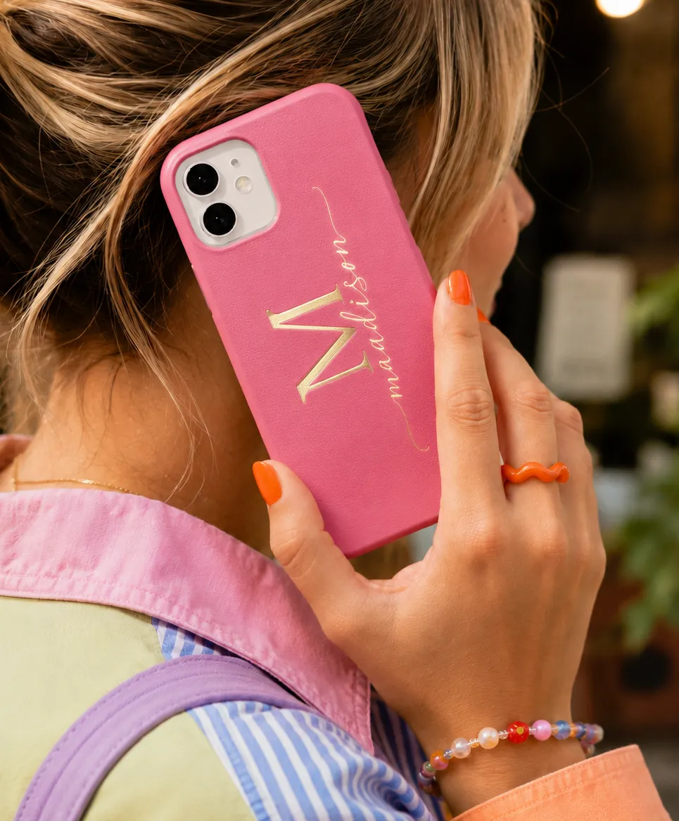Pink leather phone case personalized with a gold foil monogram and custom name