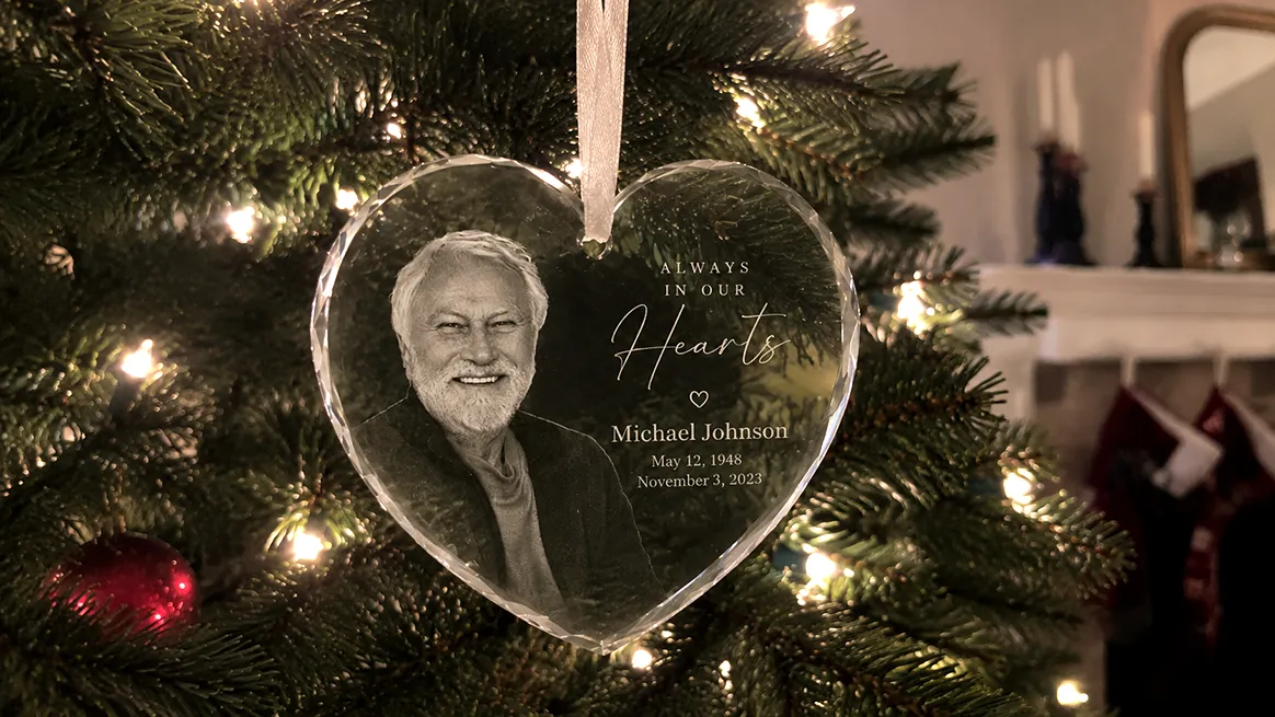 Personalized heart-shaped glass ornament engraved with a custom photo, name, and memorial message.
