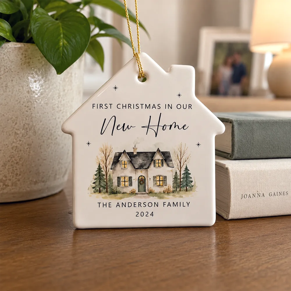 Personalized house-shaped ceramic ornament featuring a custom family name and first Christmas in a new home design.