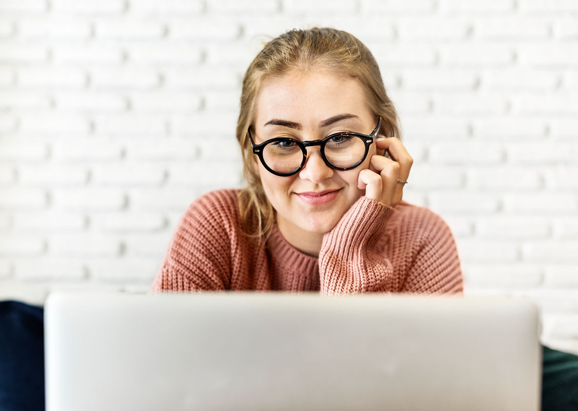woman with glasses looking at computer screen