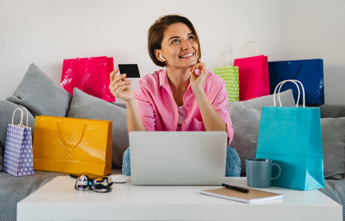 Girl with a credit card in her hand, surrounded by gift bags
