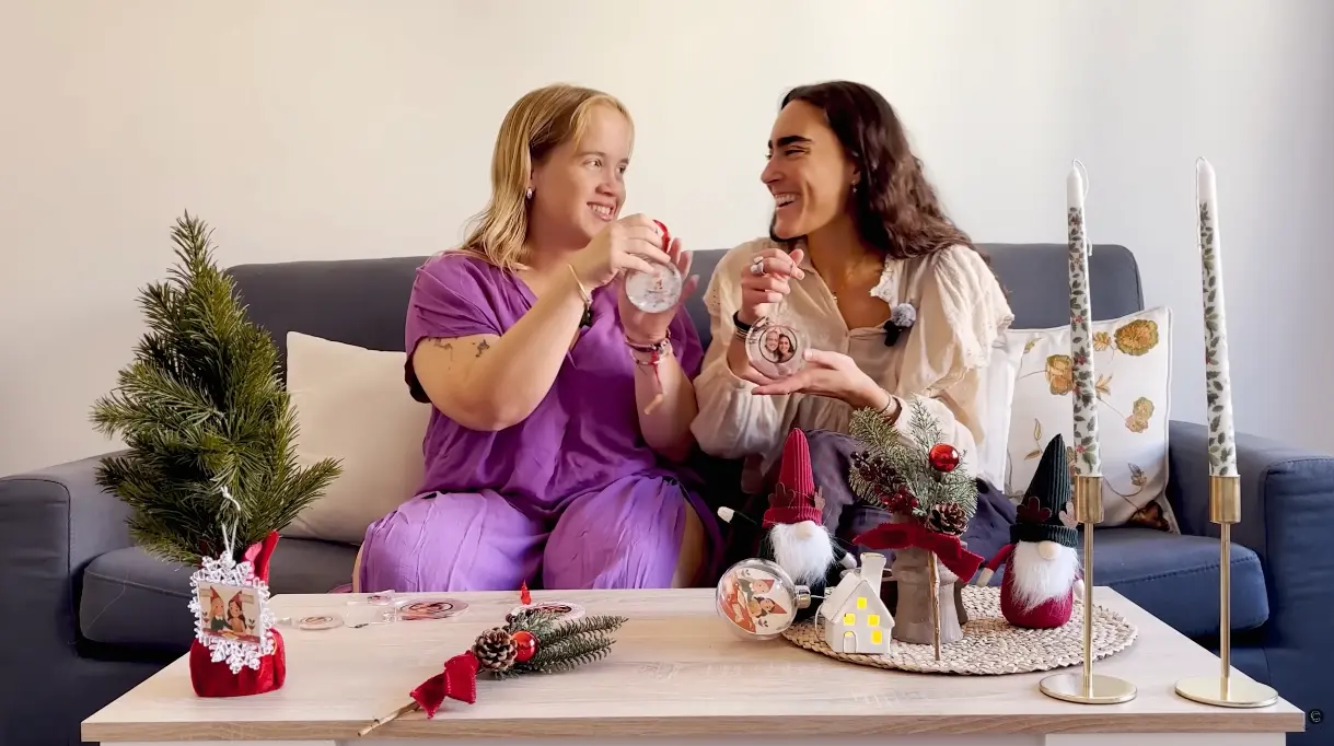 Two friends showing christmas personalized ornaments made with Customily