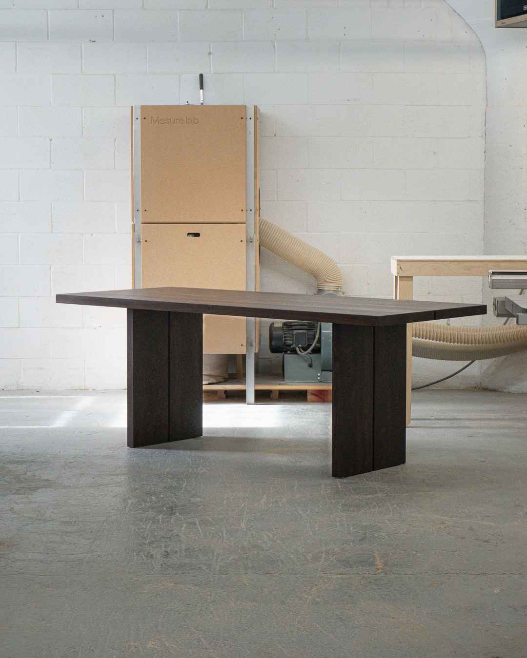 Une chaise en bois contreplaqué d'érable courbé, teinte à l'huile noire, avec des joints tenon et mortaise, vu en angle.