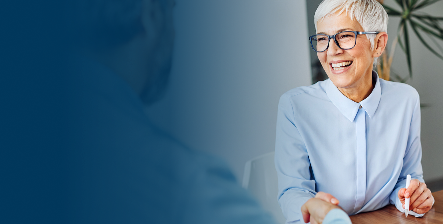 A financial advisor seated at a desk in a bright office.