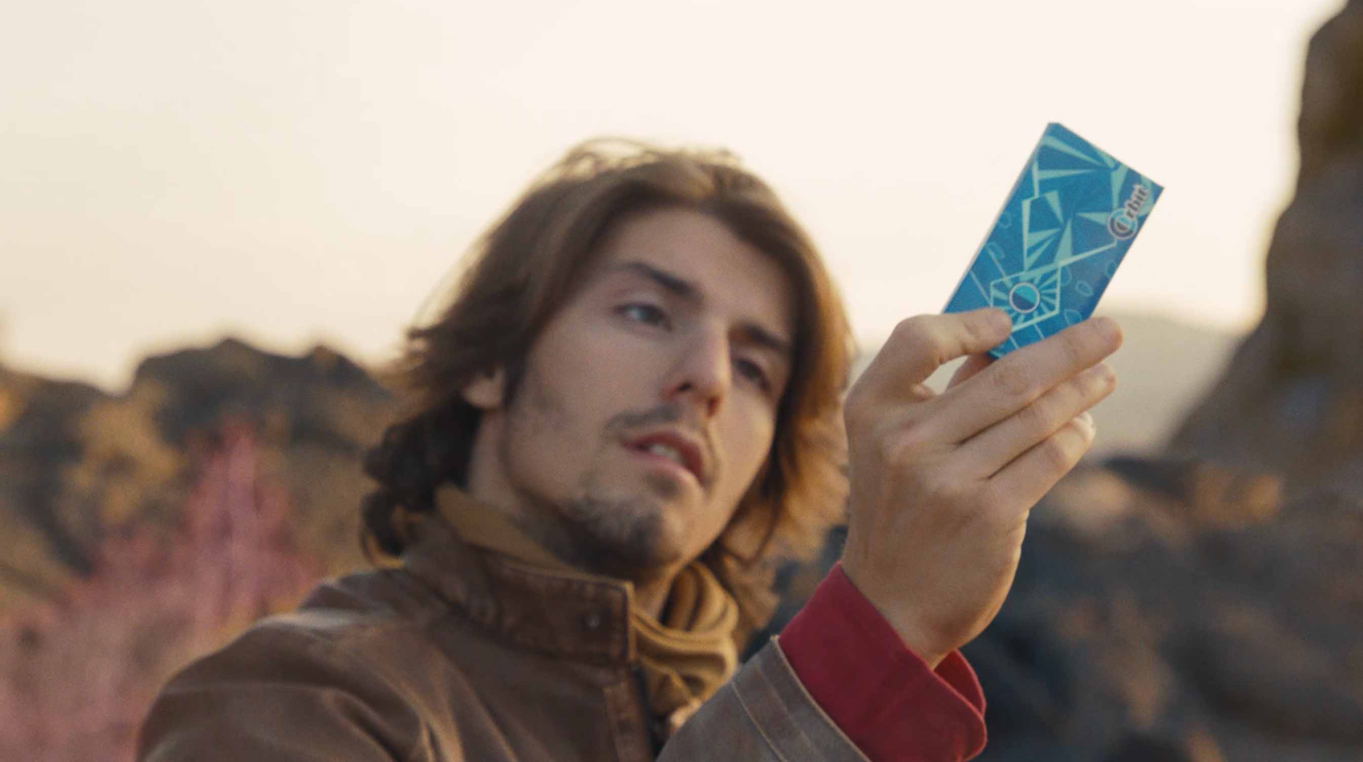 young man holding up a pack of gum in the desert, Orbit commercial