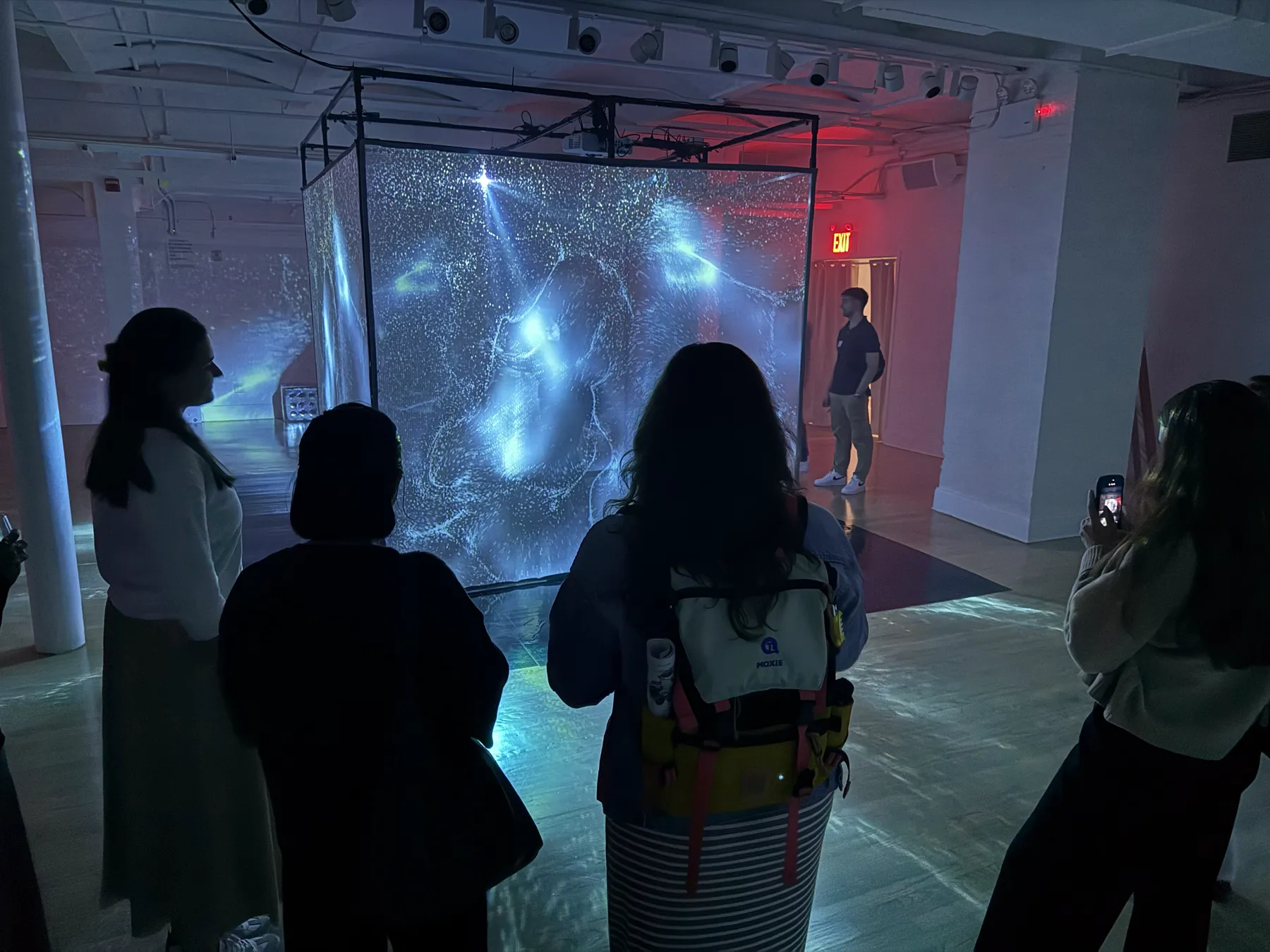 crowd watching the projection cube light up the room