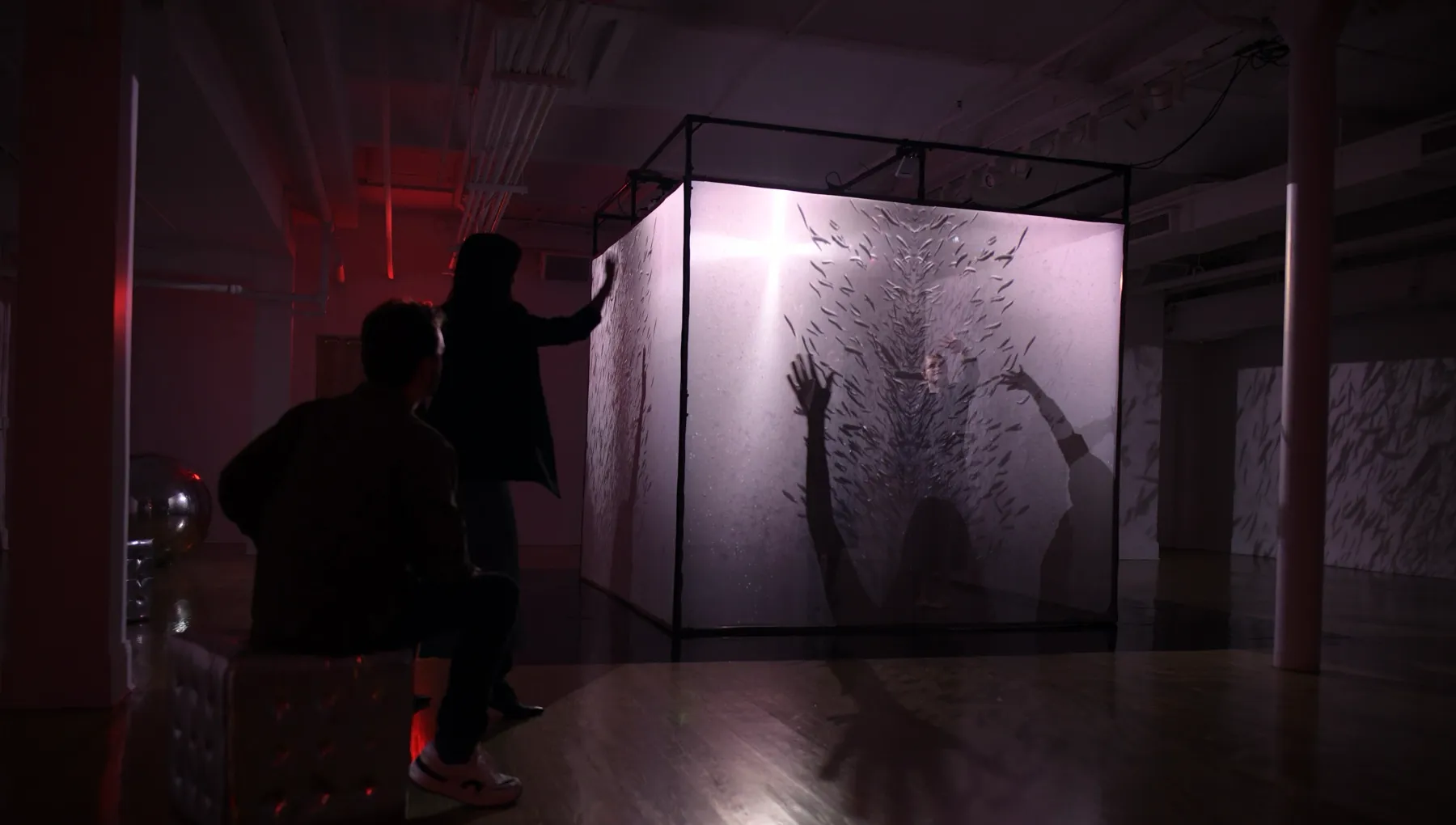 guests touching the glowing cube wall