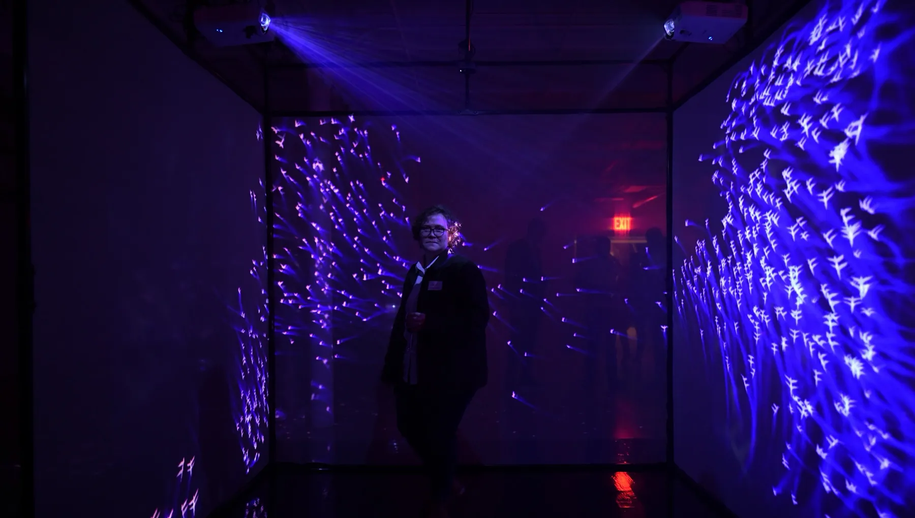 guest standing in the cube surrounded by flocks of light