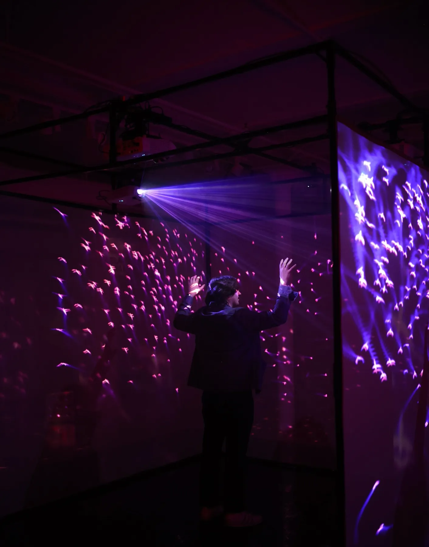 guest reaching up inside the cube as purple light flows past