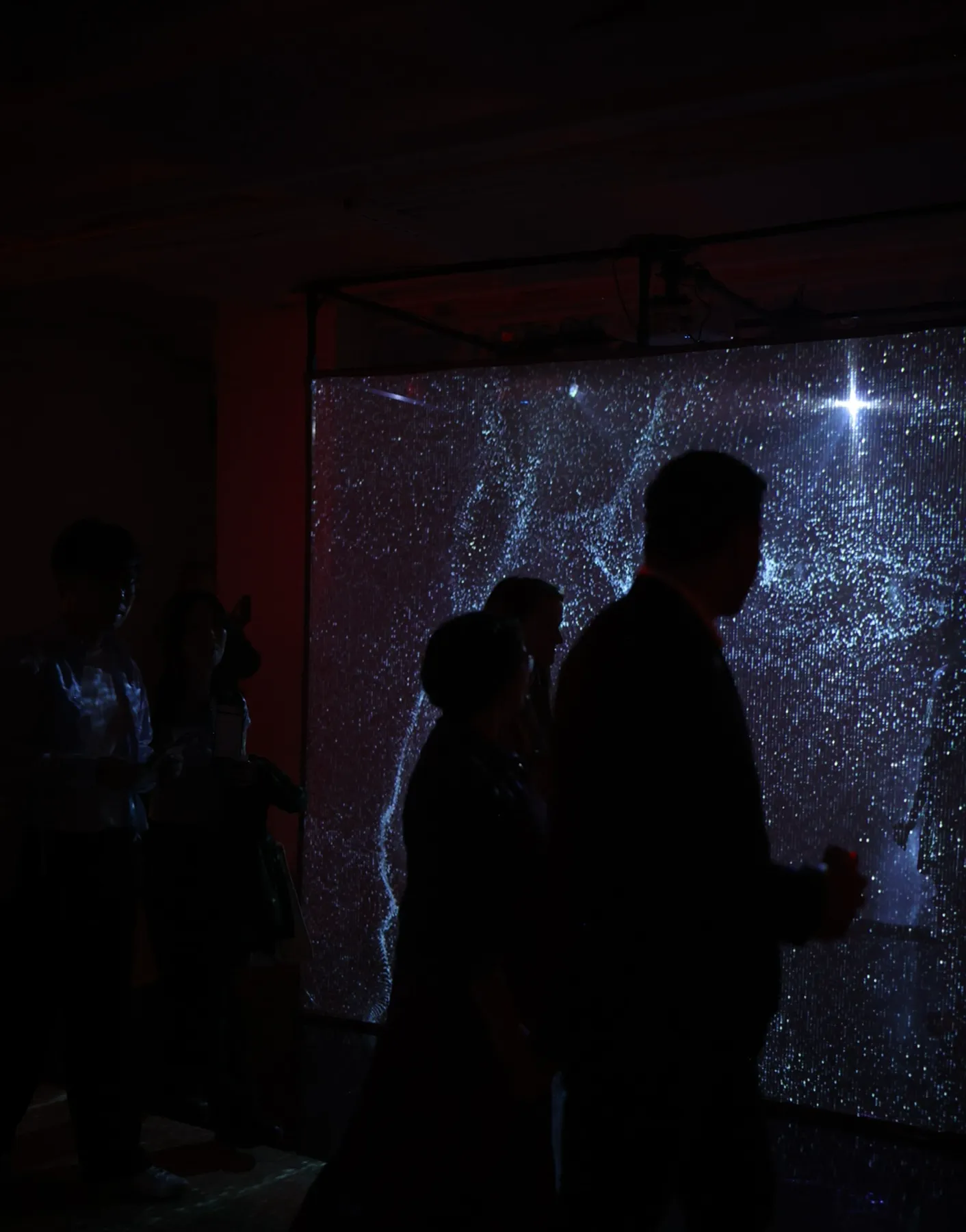 guests walking past the lit projection cube