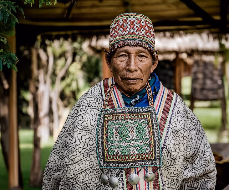 A traditional Peruvian shaman dressed in traditional Shipibo clothing at an ayahuasca retreat.