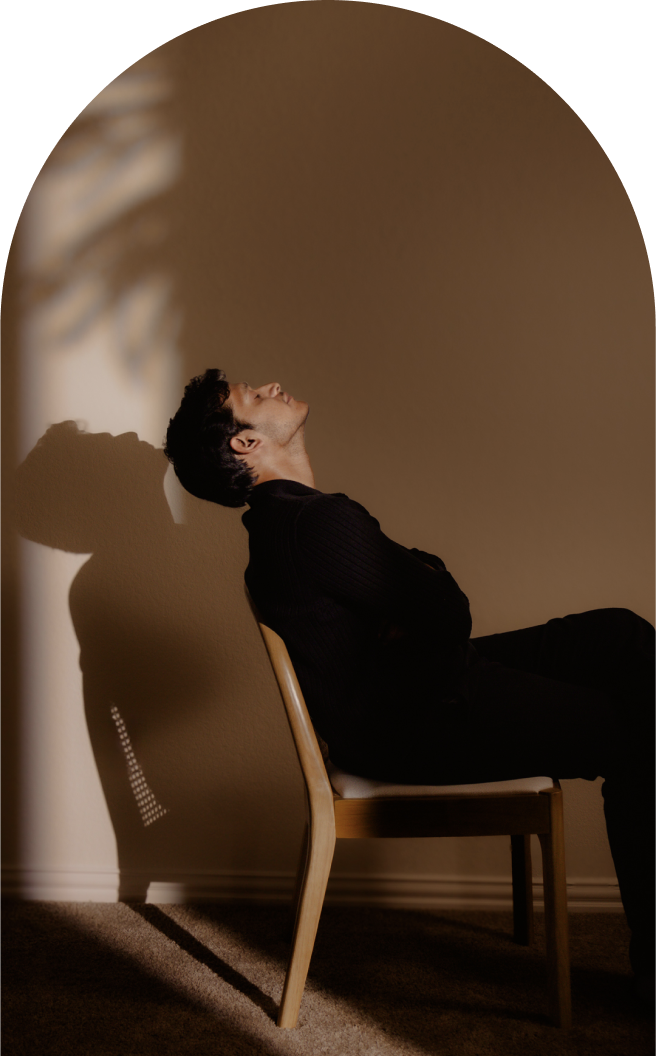 Man Sitting on a chair with a shadow casting on wall