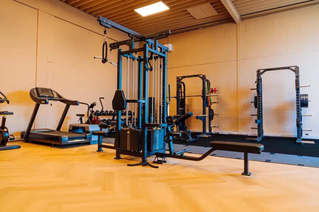 Trainingsruimte van Fitbase met kabelstation, loopband en squatrekken