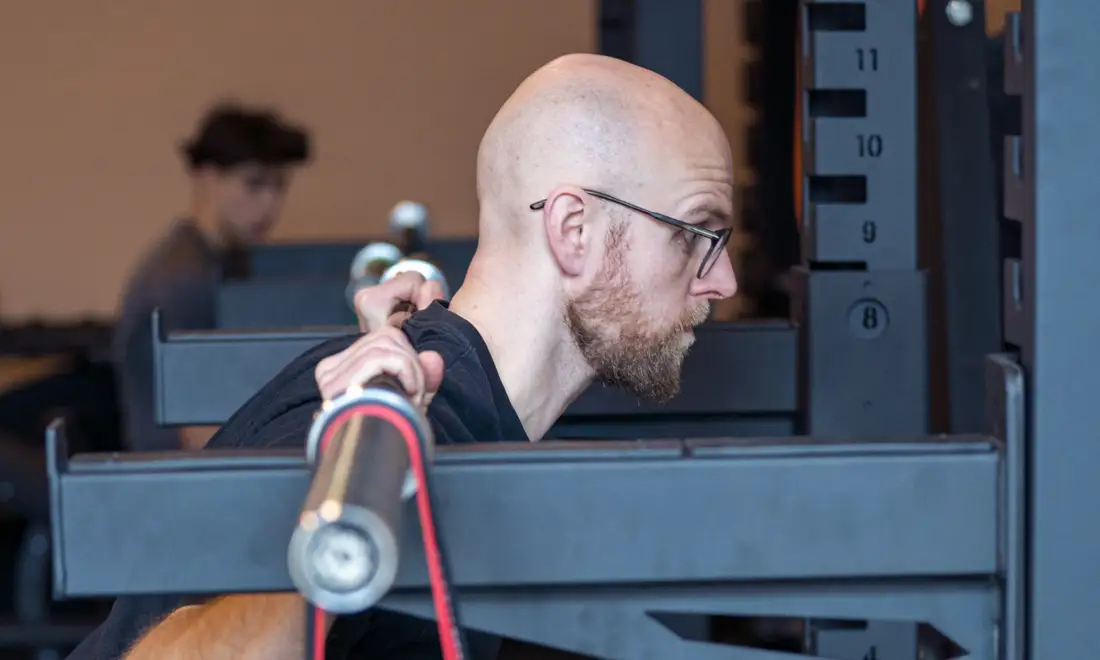 Roald Otten, fysiotherapeut bij Fitbase, doet een squat in het rek in de gym in Almere Buiten