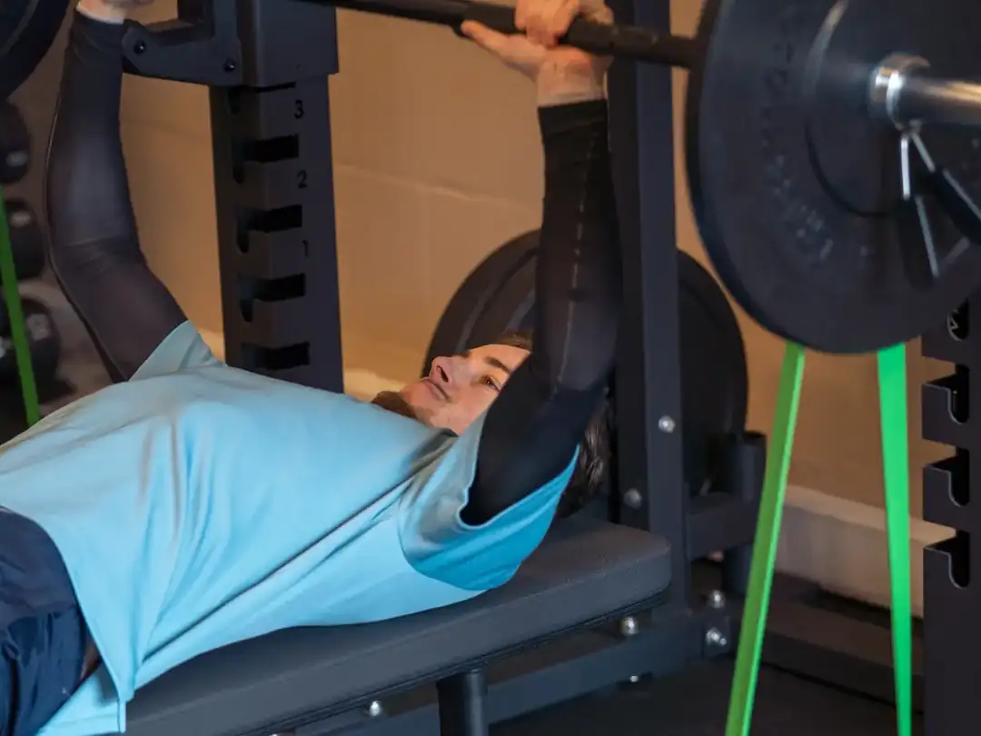 Sporter doet bankdrukken in het rek tijdens personal training bij Fitbase in Almere Buiten