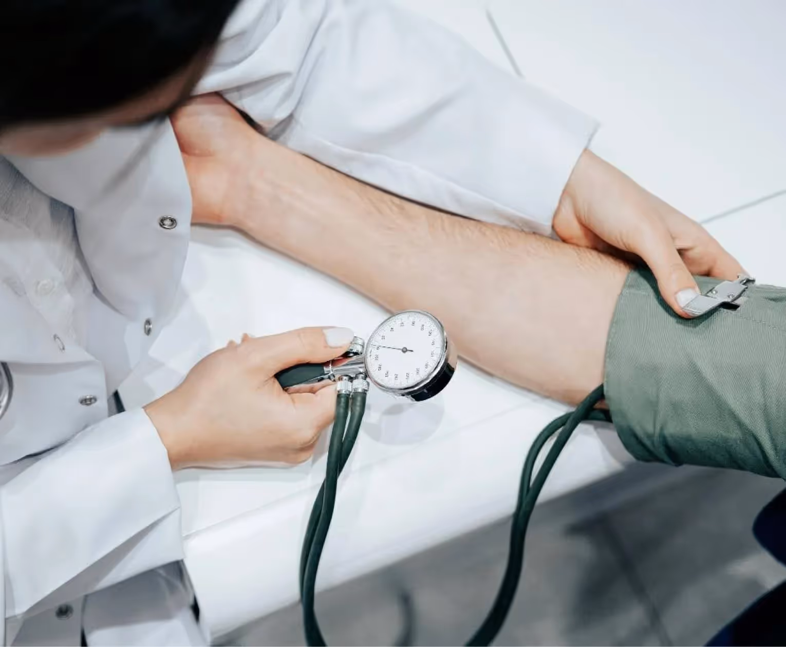 Professionnel de santé prenant la tension artérielle d’un patient, pour illustrer le suivi régulier des patients chroniques grâce à la téléexpertise.