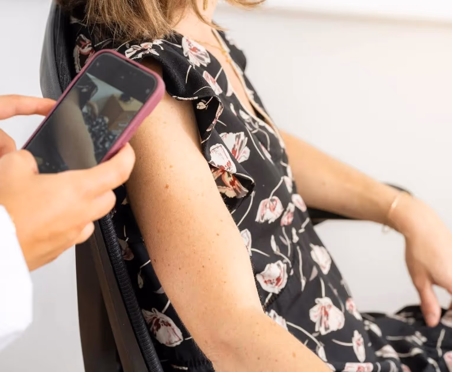 Médecin généraliste prenant en photo le grain de beauté d’une patiente pour une demande de téléexpertise auprès d’un dermatologue.