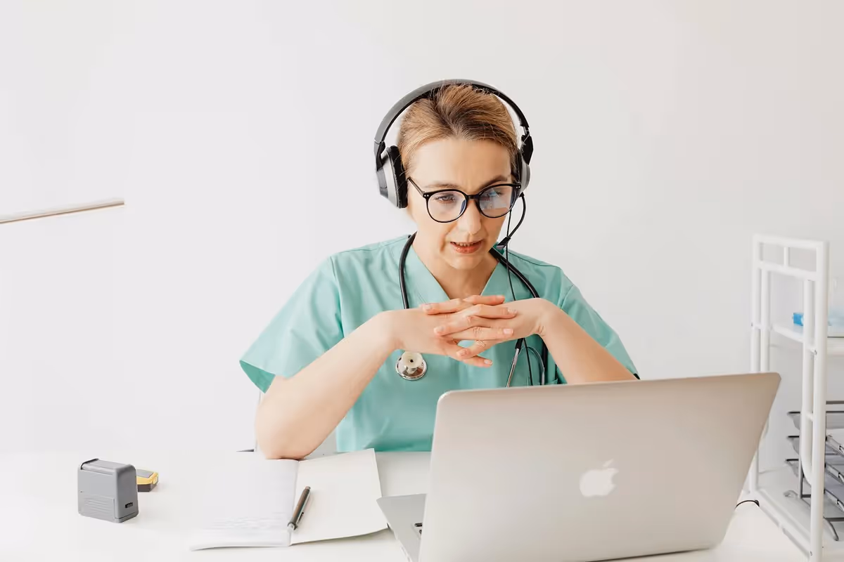 Une professionnelle de santé travaillant en établissement de soins communique via un ordinateur.