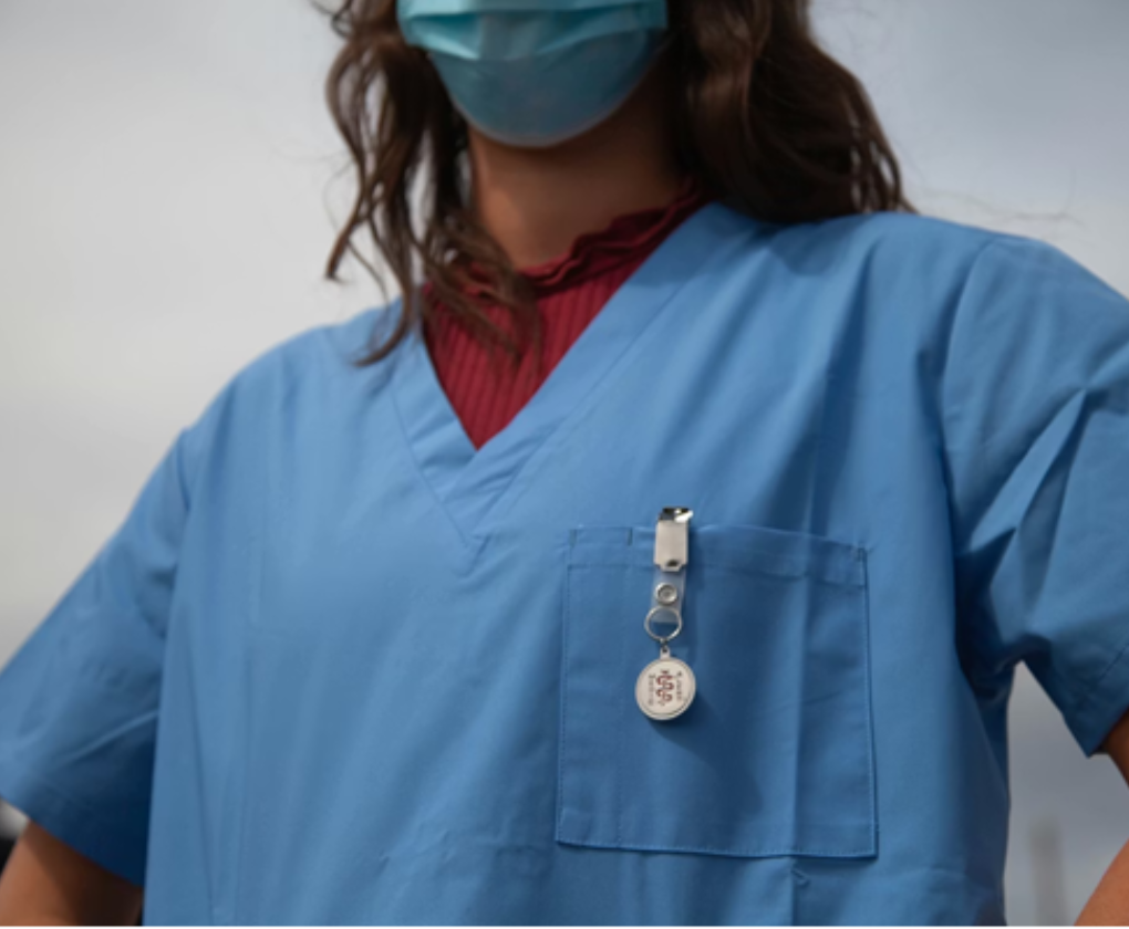 Une infirmière portant une blouse et un masque chirurgical.