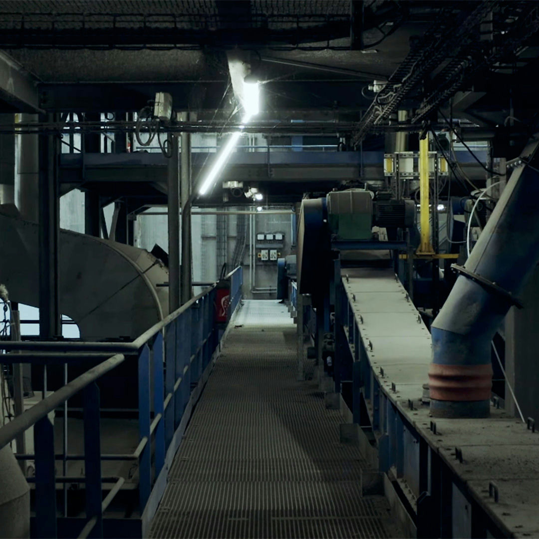 Plan de tournage documentaire illustrant une étape de tri et de traitement des déchets.