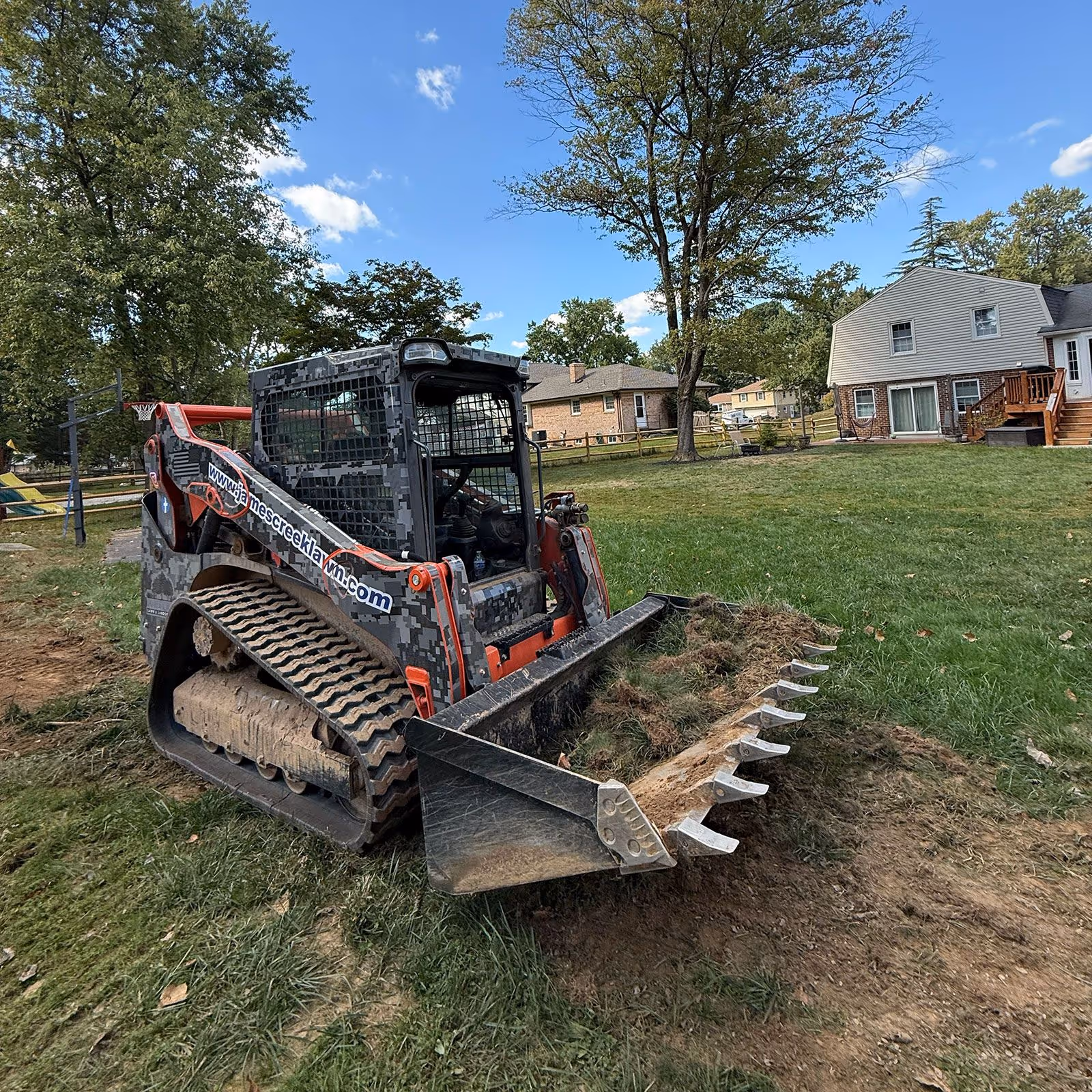 Skid steer in action near me for lawn and landscape installation