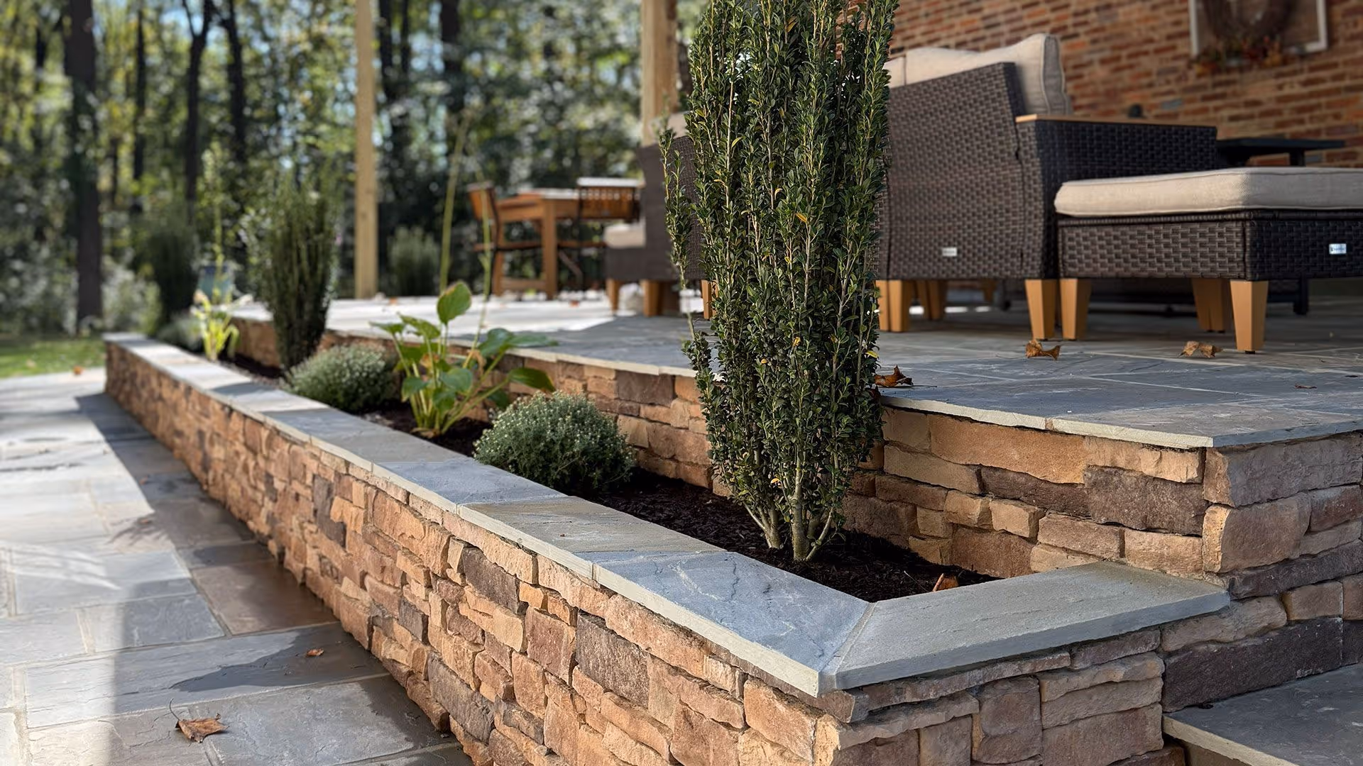 Homepage Hero image of a freshly rebuilt brick patio with small shrubs for James Creek Lawn Care in Maryland.