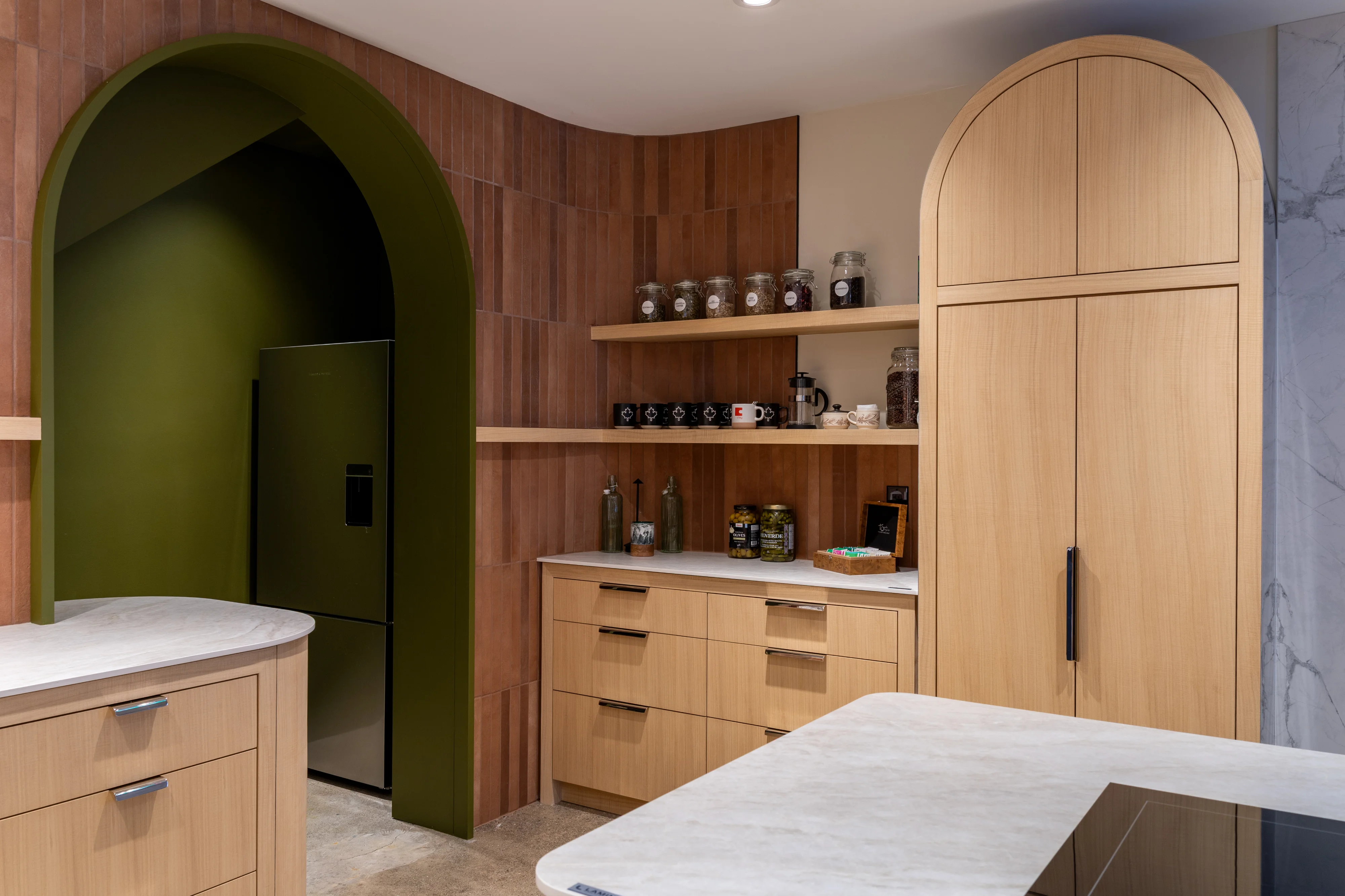 interior design of kitchen with green doorway, arched cabinets, marble counters