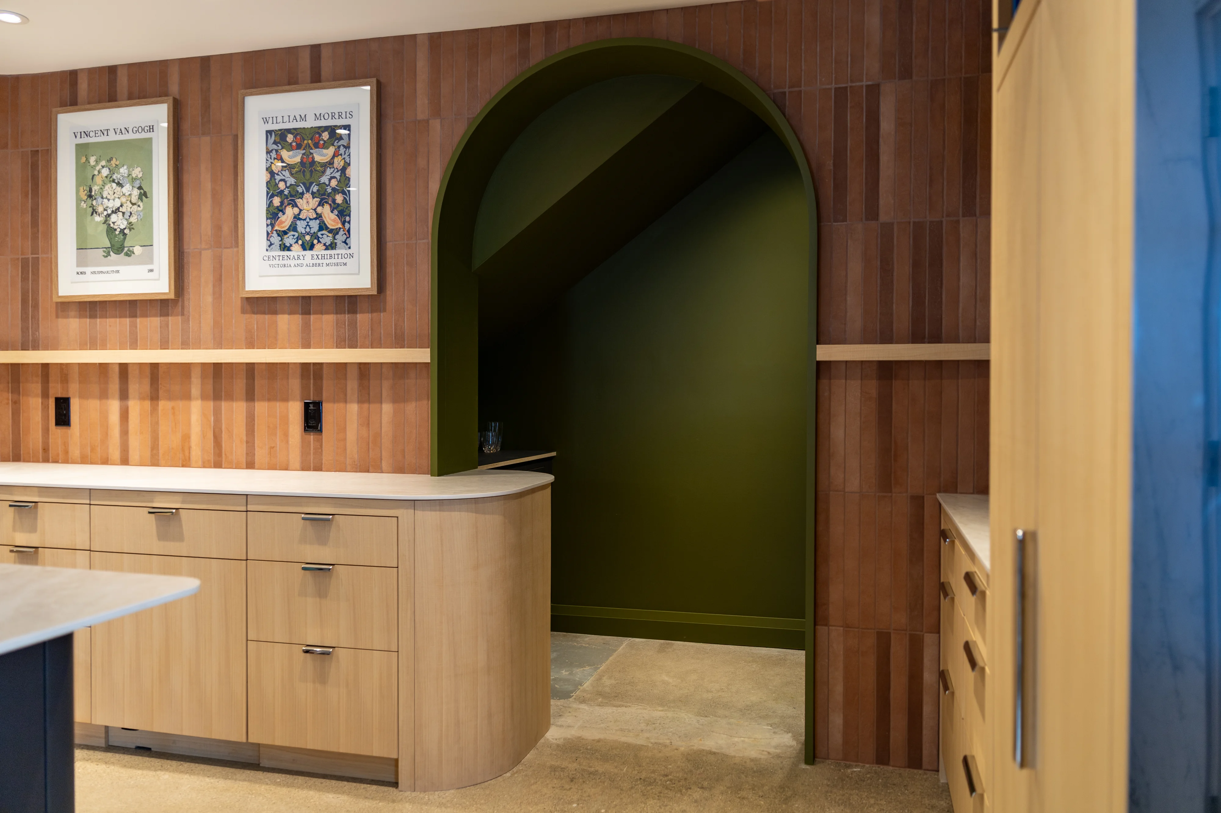 interior kitchen with green door way, flower paintings on the wall, light cabinets and cupboards