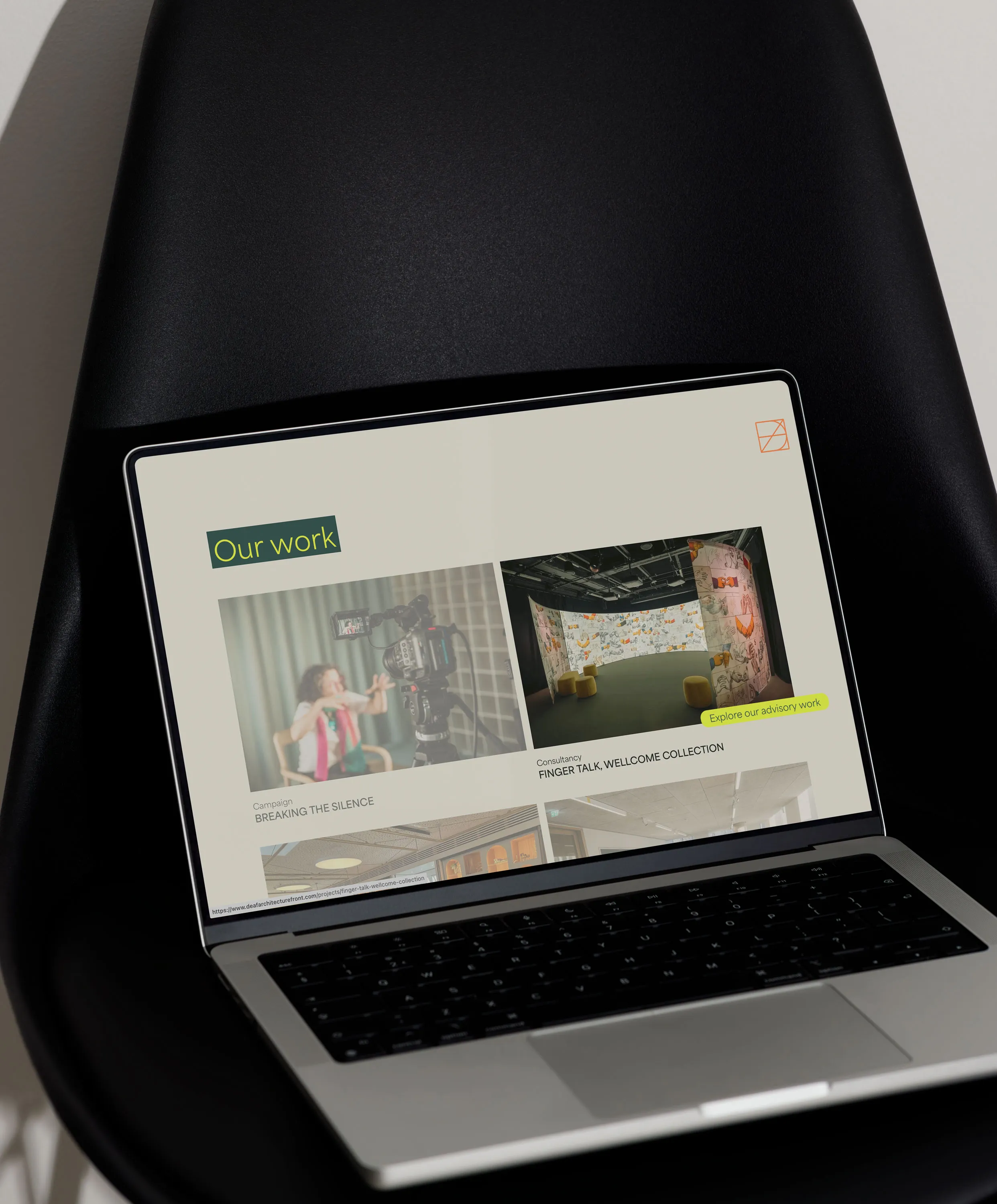 MacBook mockup showing another section of the Deaf Architecture Front website.