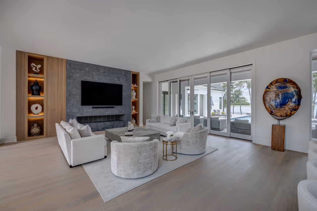 Open‑plan lounge area featuring low‑profile seating, a sculptural coffee table, and panoramic lake views