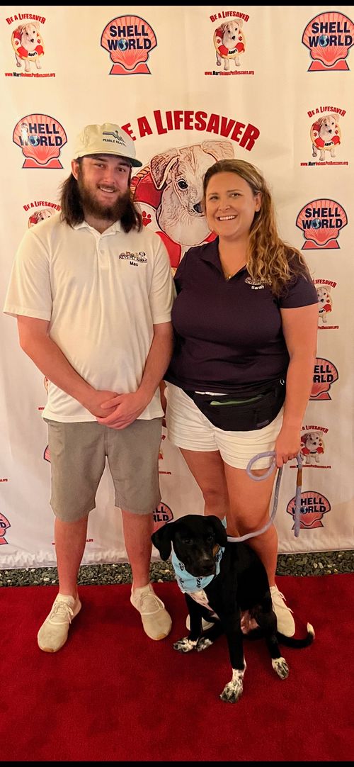 The Keys Pet Nanny family poses with a pup during a Marrvelous Pet Rescue Event.