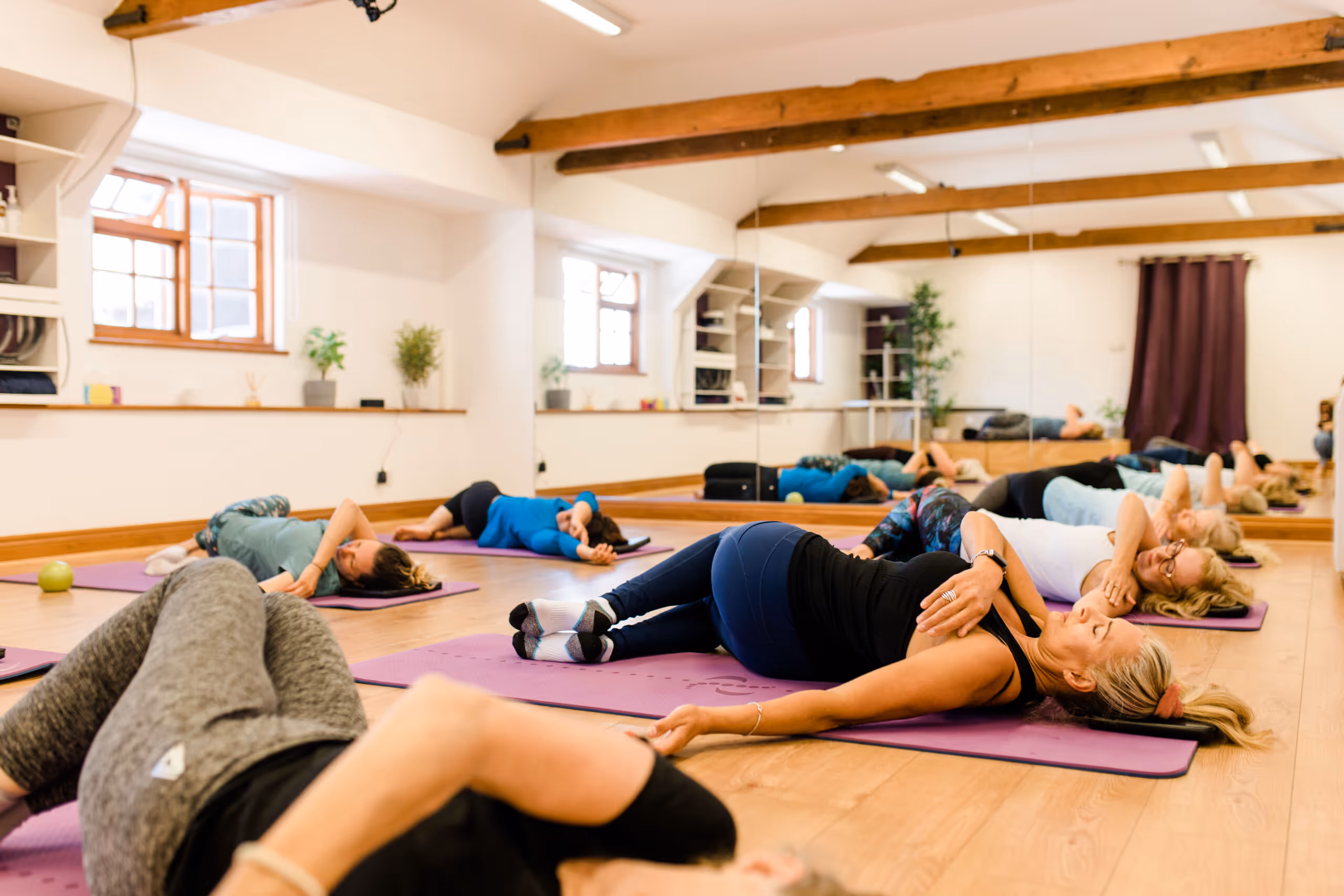 A group of people stretching on yoga mats, participating in a wellness and recovery class.