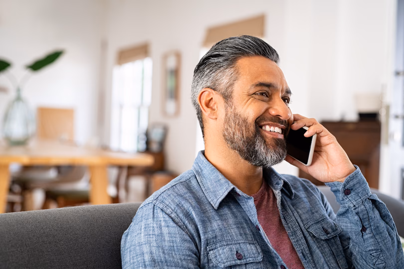 Man on phone call in home smiling