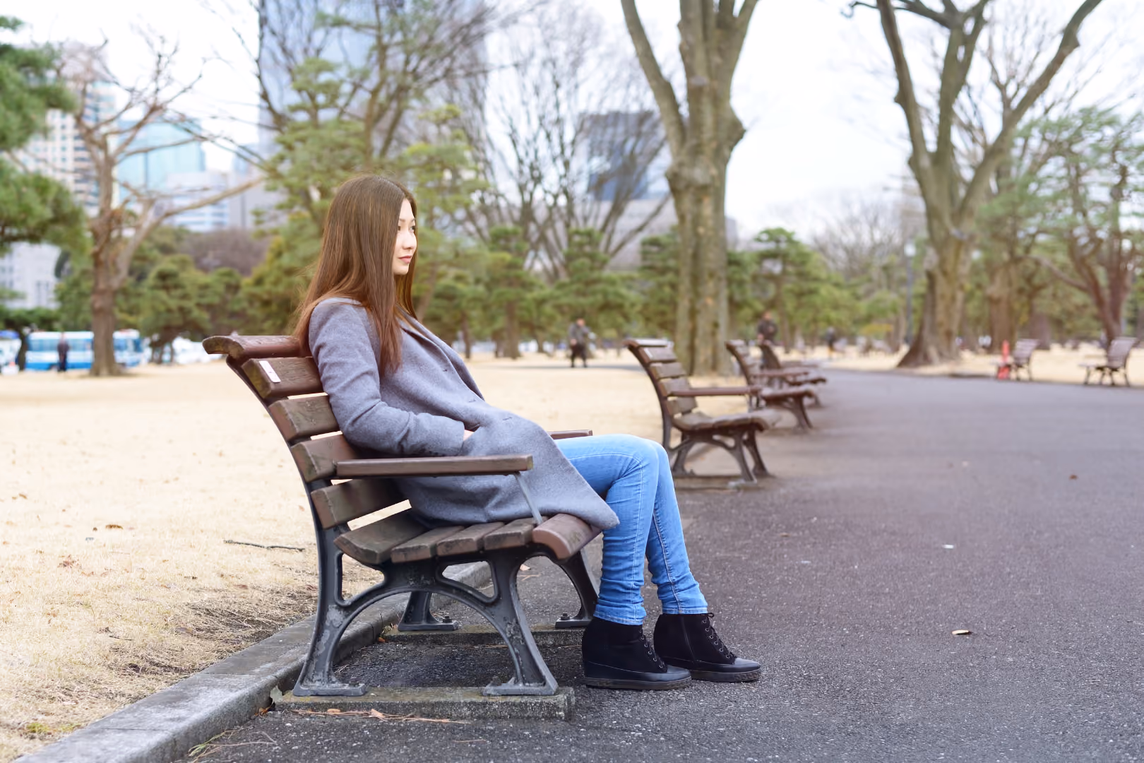 Woman sitting outside on park bench