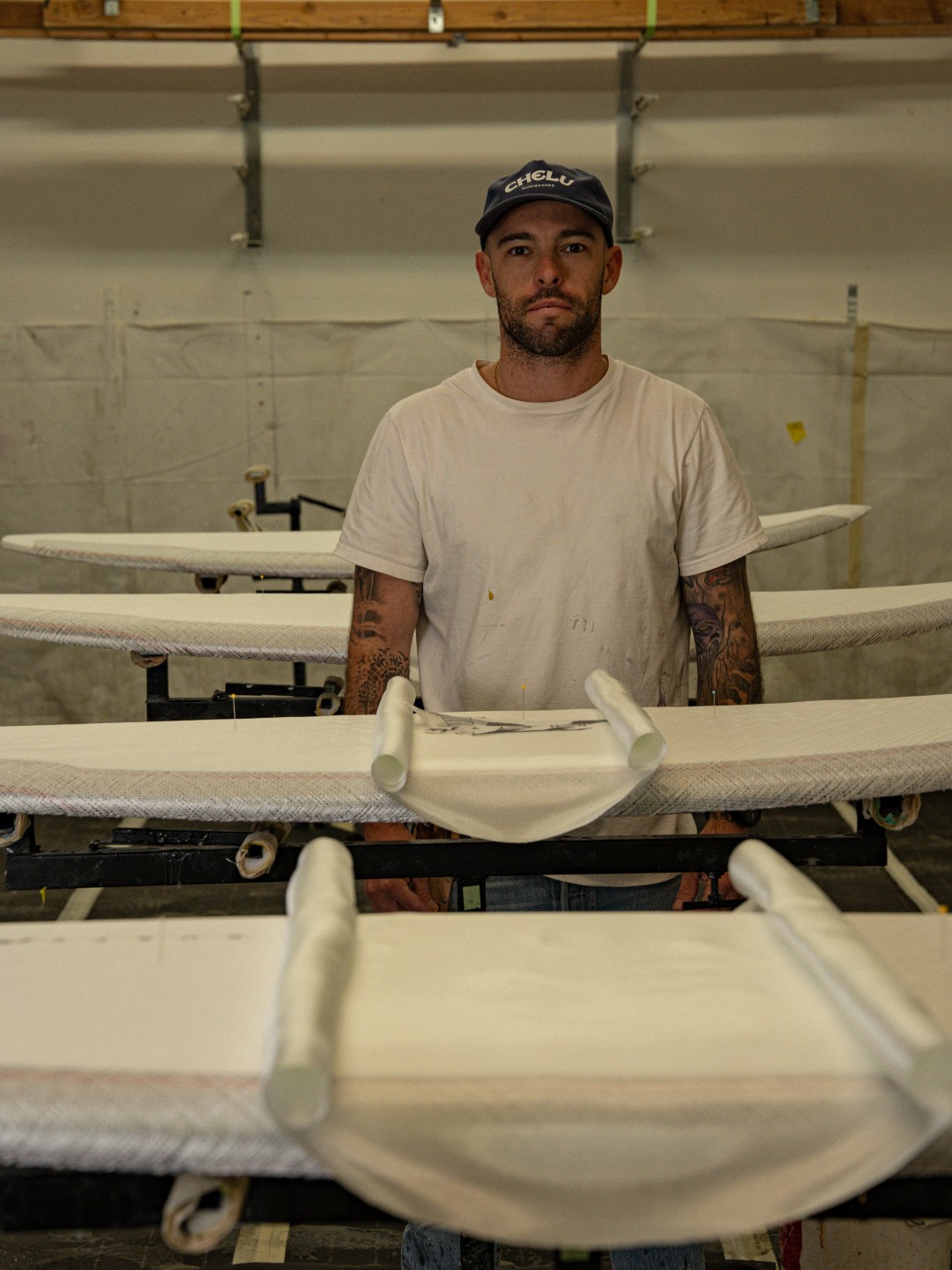 Surfer carrying handcrafted Chelu surfboards toward the beach – surf lifestyle photography