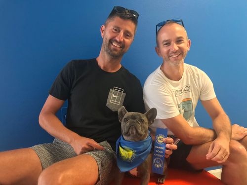 Frenchie Dog posing with 2 men