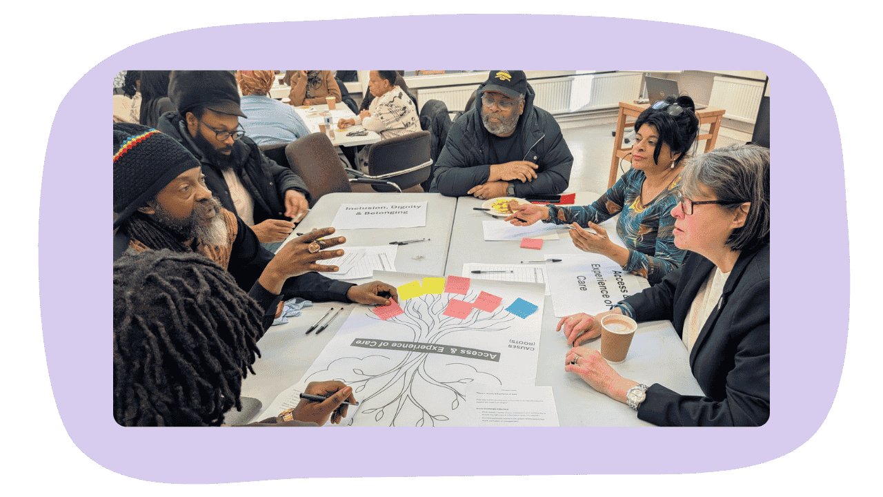 Group of diverse people sitting around table discussing topics on inclusion and access to care.