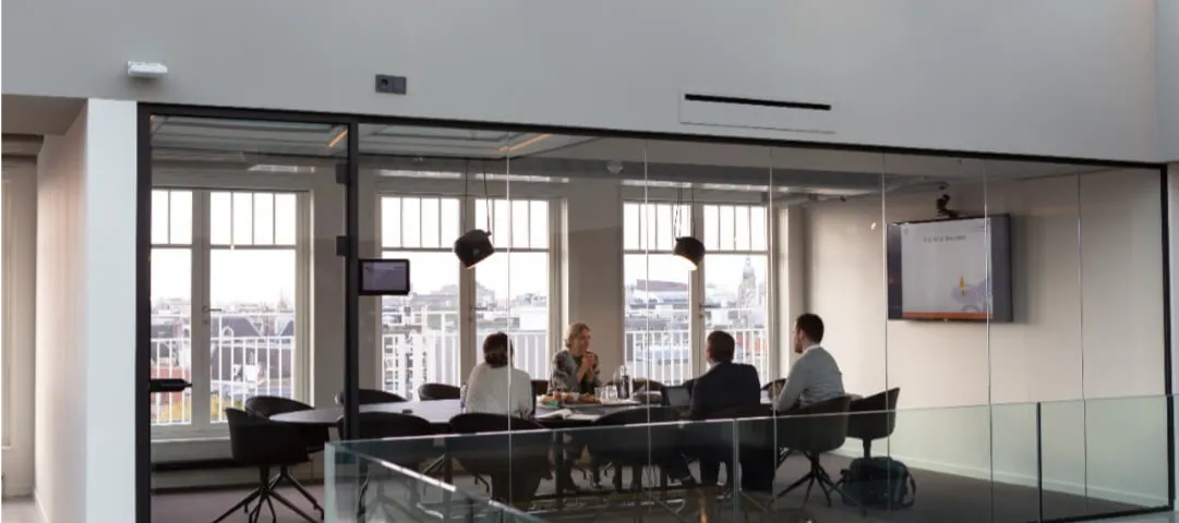 A group of people sitting around a glass table.