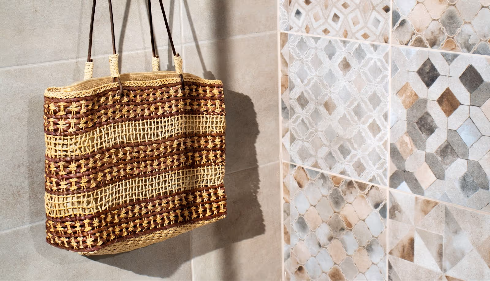 Different colored and patterned shower tiles with hand bag hanging in shower