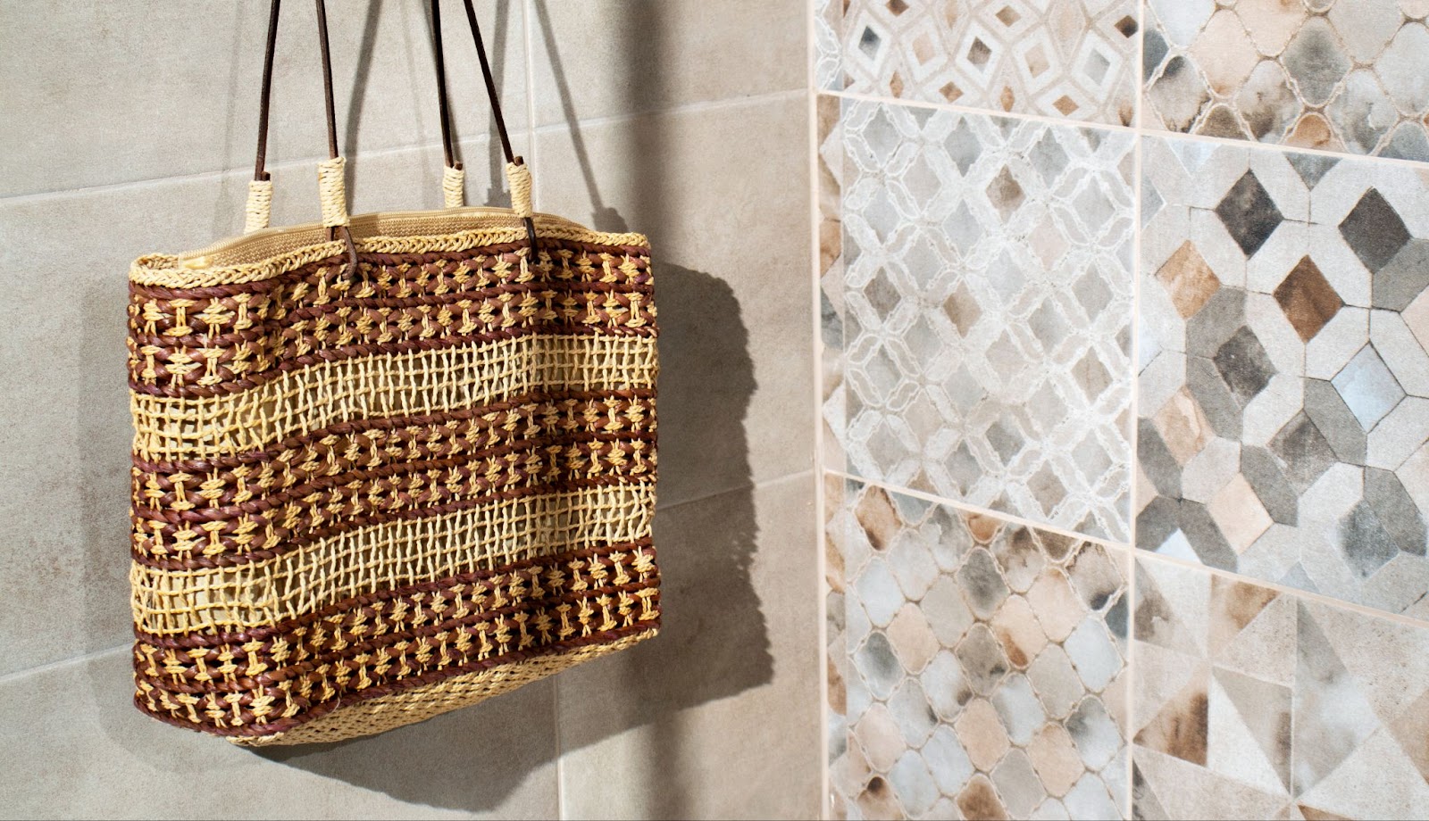 Different colored and patterned shower tiles with hand bag hanging in shower