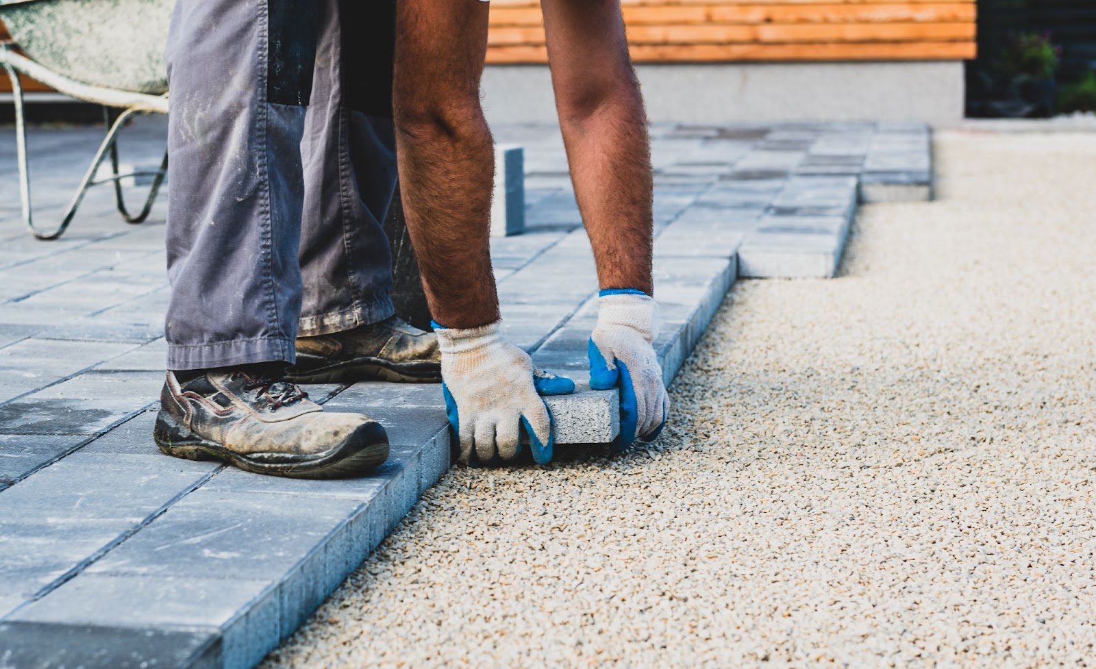 contract worker laying concrete patio tiles