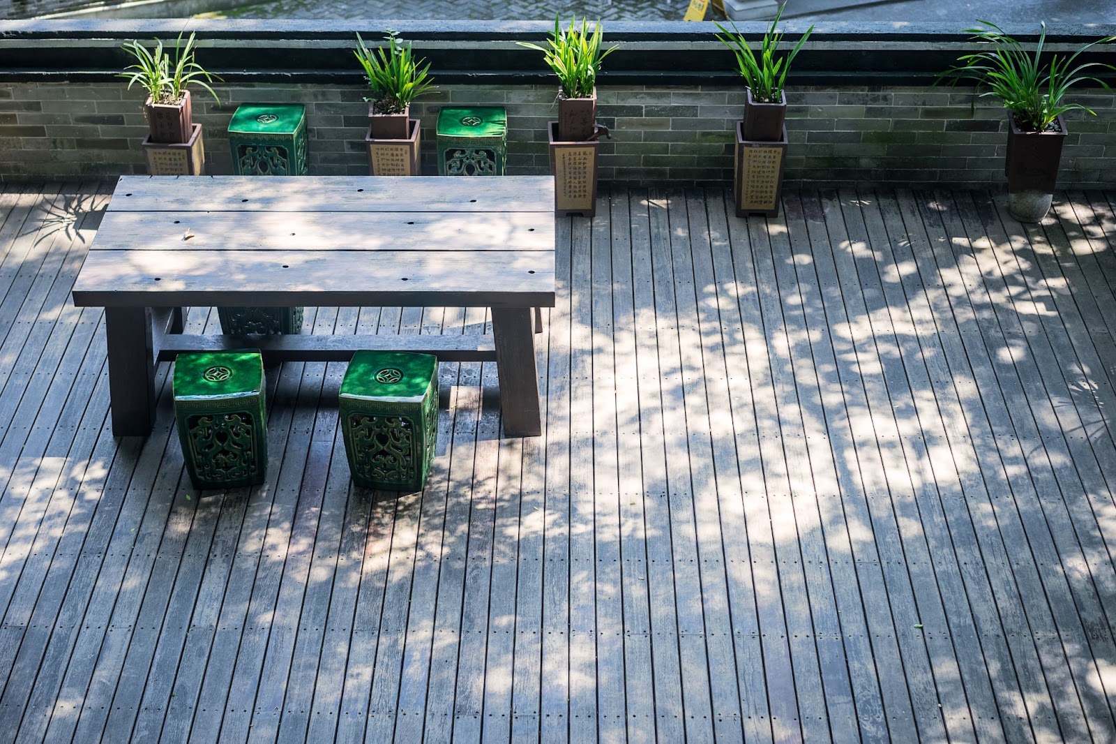 Wood look composite decking with potted plants and wooden table