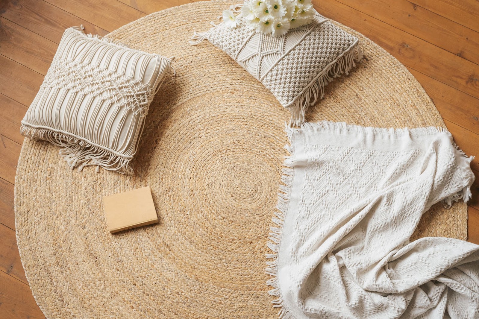 Neutral colored weaved rug with macrame pillows and throw
