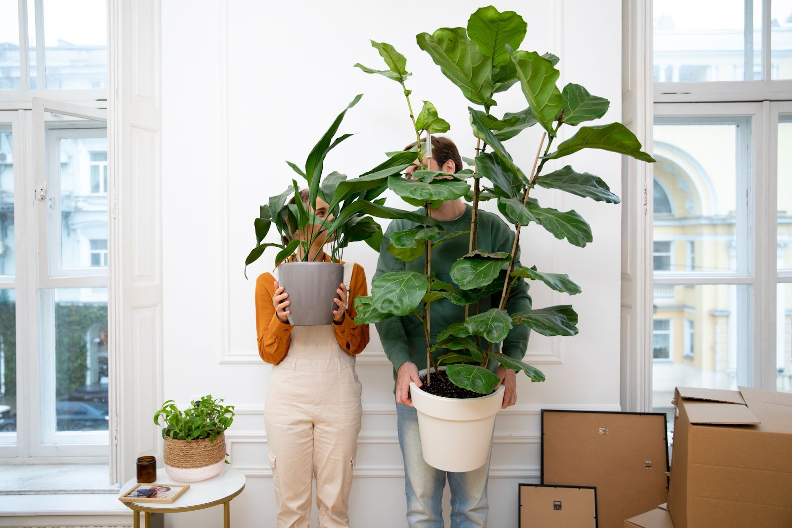 A couple holding indoor plants