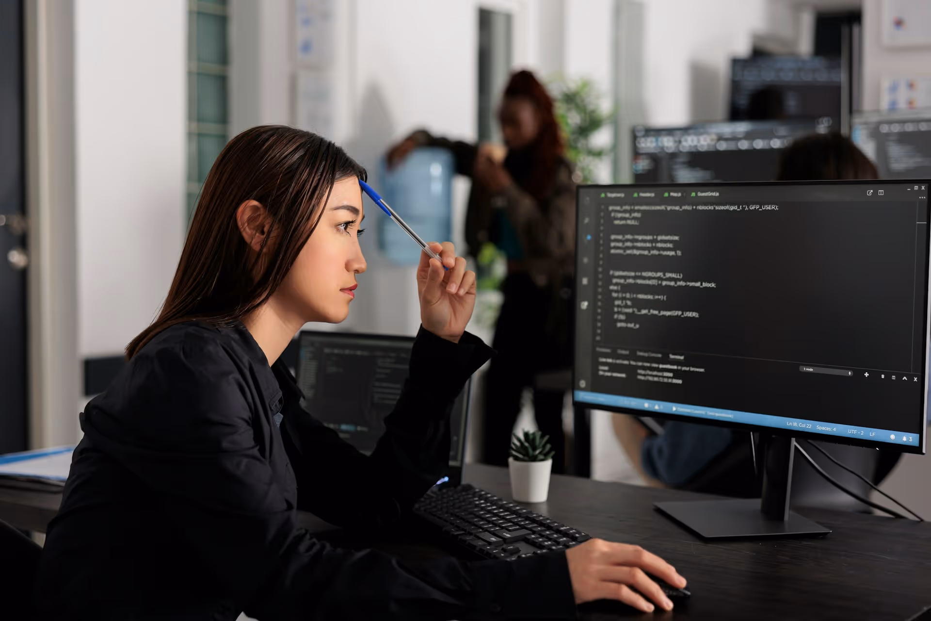 Professionnelle travaillant devant un écran affichant du code.
