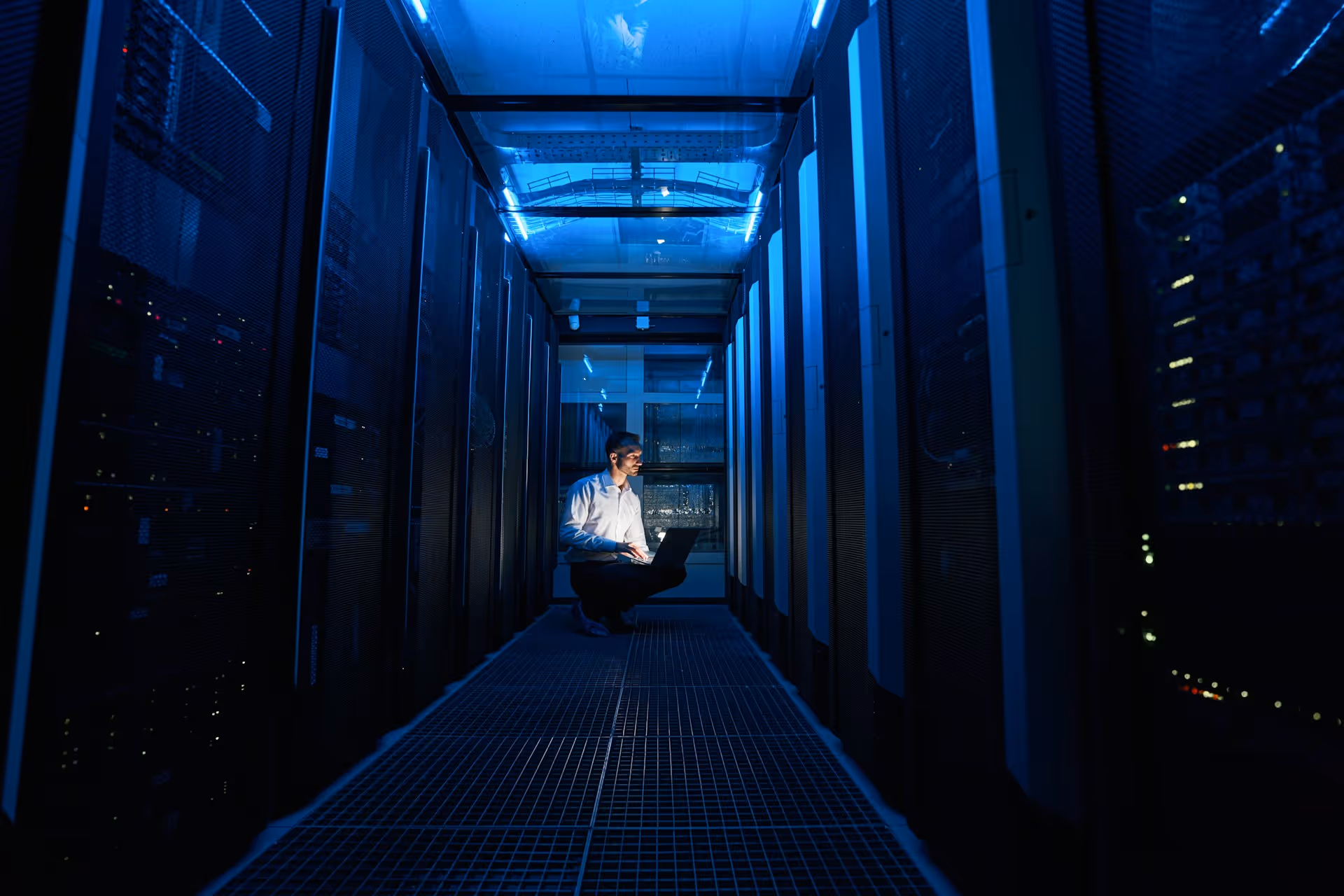 Dark data-centre aisle lined with server racks.