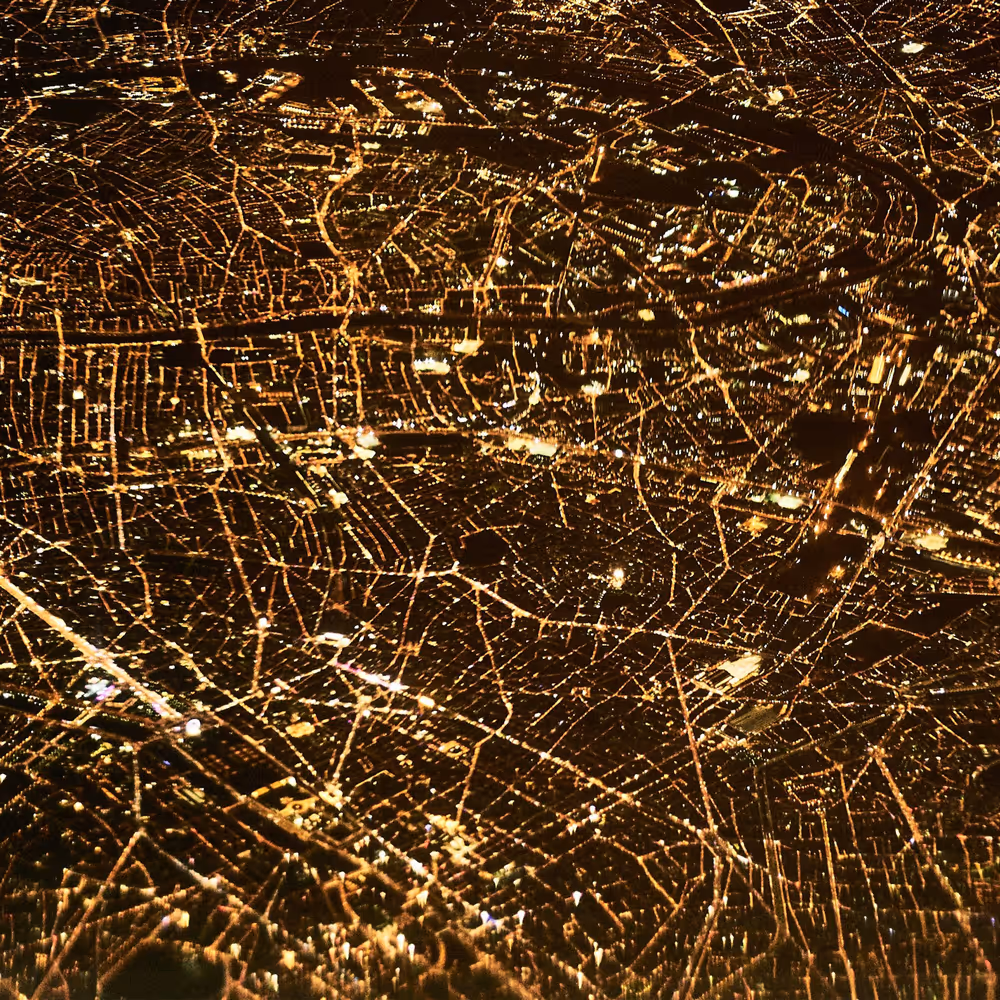 Aerial night view of an illuminated city evoking data.
