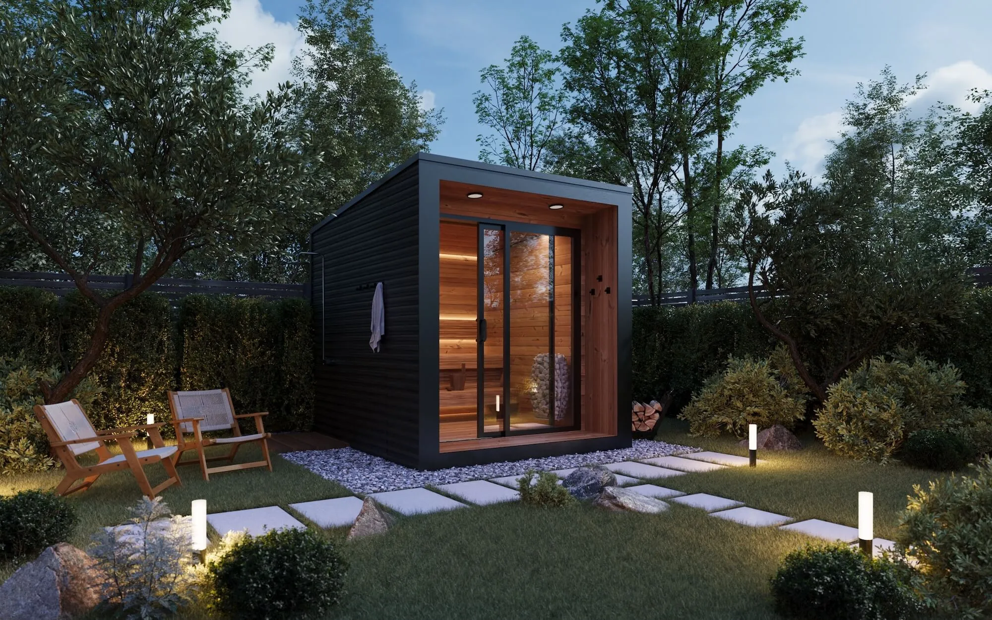 Modern backyard sauna with glass doors illuminated inside, surrounded by greenery and outdoor seating.