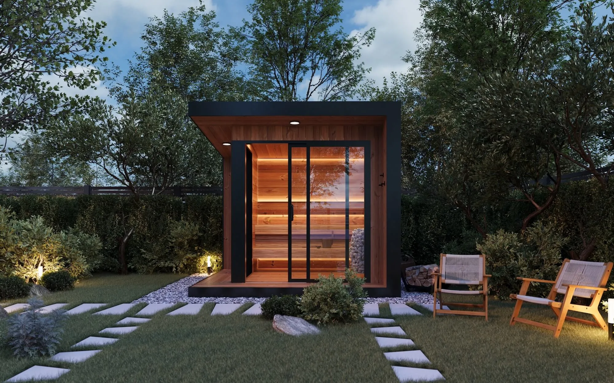 Modern wooden outdoor sauna with glass sliding door lit warmly inside, surrounded by greenery and lawn with two wooden chairs on the right.