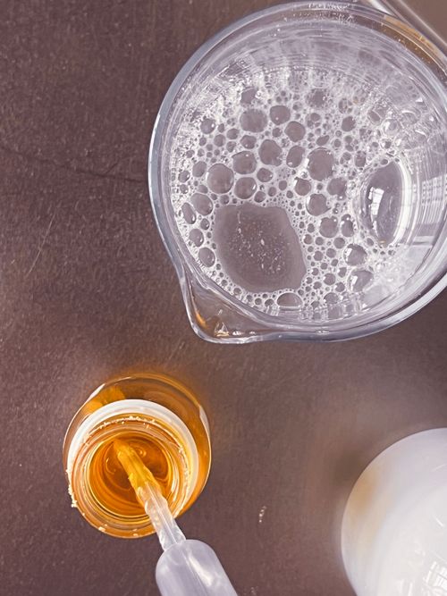 foaming formula in a lab beaker with a spatula